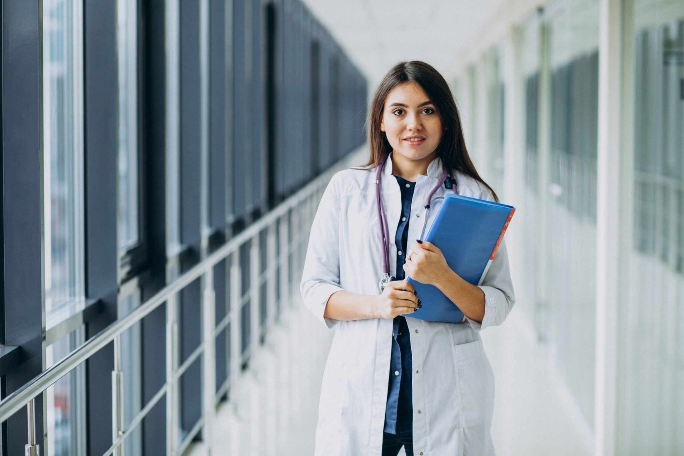 Attractive female doctor standing with documents at the hospital